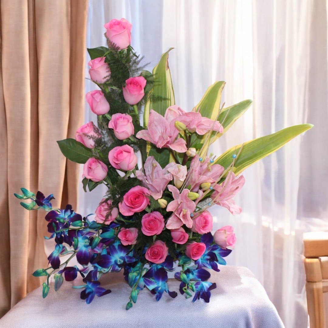 Elegant pink roses, lilies, and blue orchids in Enduring Memories floral basket by BetterGiftFlowers