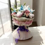 Elegant Lily, Carnation & Rose Bouquet by BetterGiftFlowers - a delicate arrangement of lilies, carnations, and roses wrapped with a purple bow.